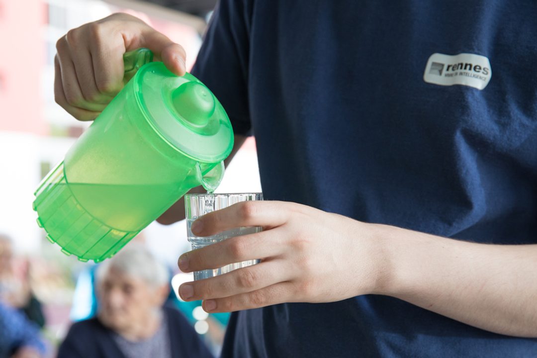 Une personne verse de l’eau dans un verre.