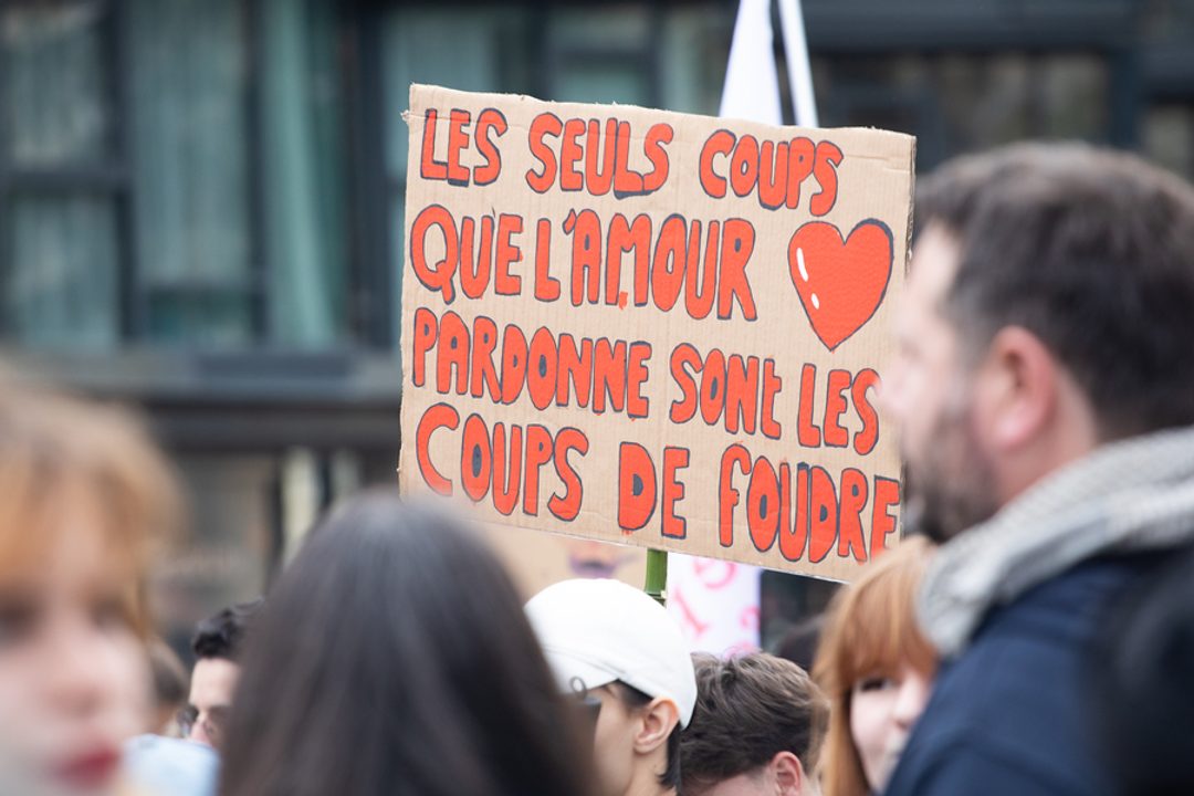 Personnes dans la rue avec pancartes.